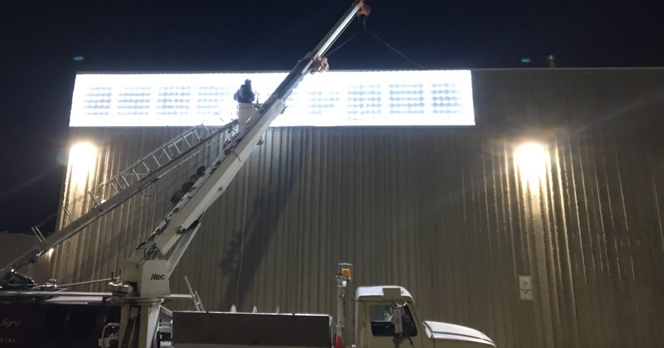 erecting-business-sign-at-night-building-exterior